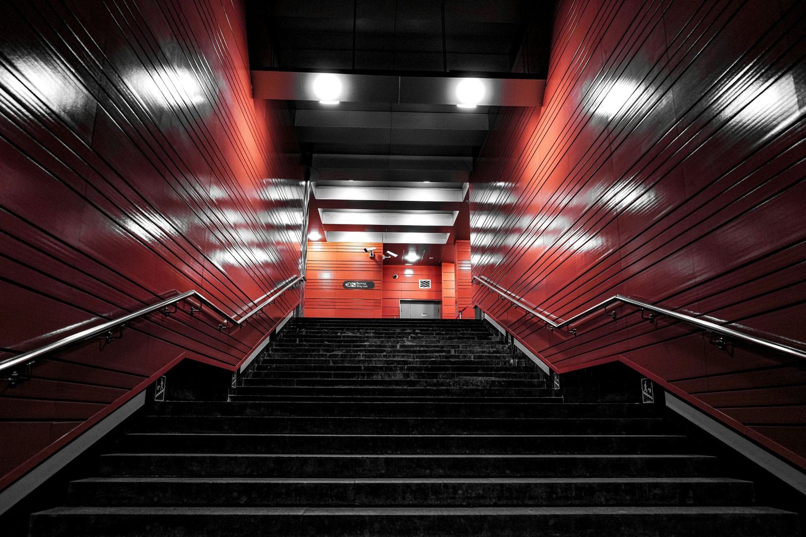 Escadaria de metrô com paredes vermelhas vista de baixo